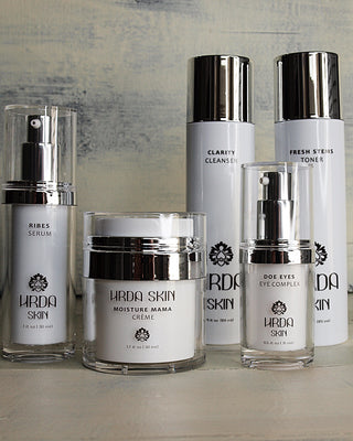 Collection of HRDa Skin skincare products on a wooden surface with a neutral background.